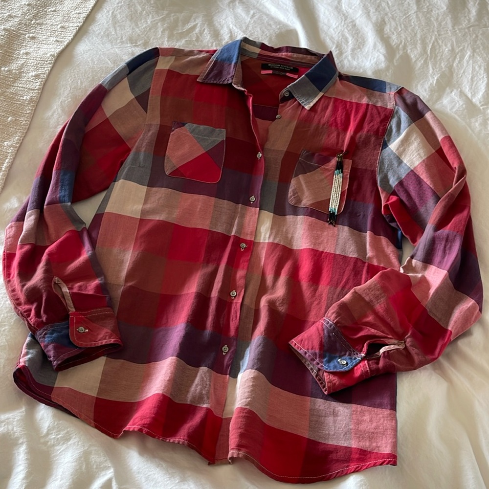 High end plaid top with tassel detail and vintage look.